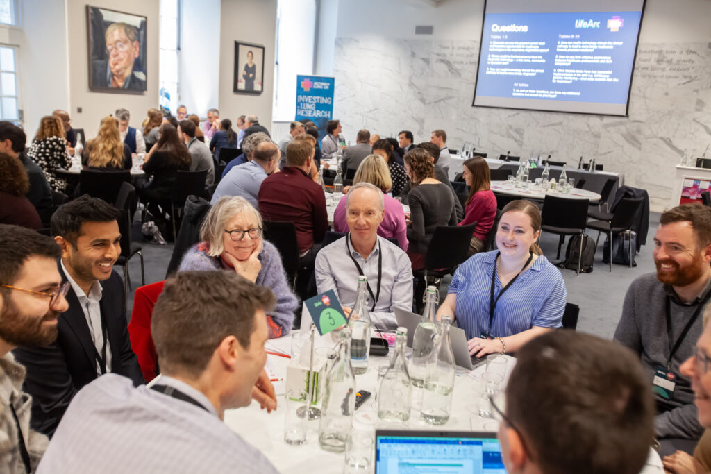 A team of Bronchiectasis research professionals conversing around a table.