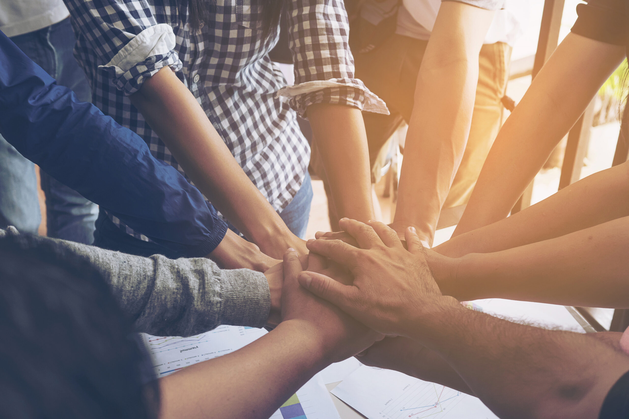 People joining hands together during their meeting